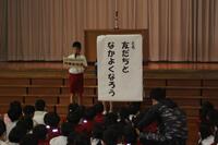 1人の児童の右側に「友だちとなかよくなろう」と書かれた大きな紙が掲示されている写真