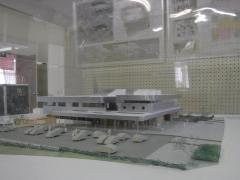 2階建ての建物や駐車場の模型がケース越しに置かれている写真