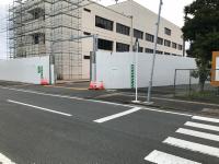 工事用足場が側面に掛けられている白い建物の写真