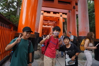 千本鳥居の前でポーズをとる3人の児童の写真
