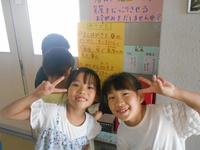 にっこりポストの前でポーズをとっている生徒の写真