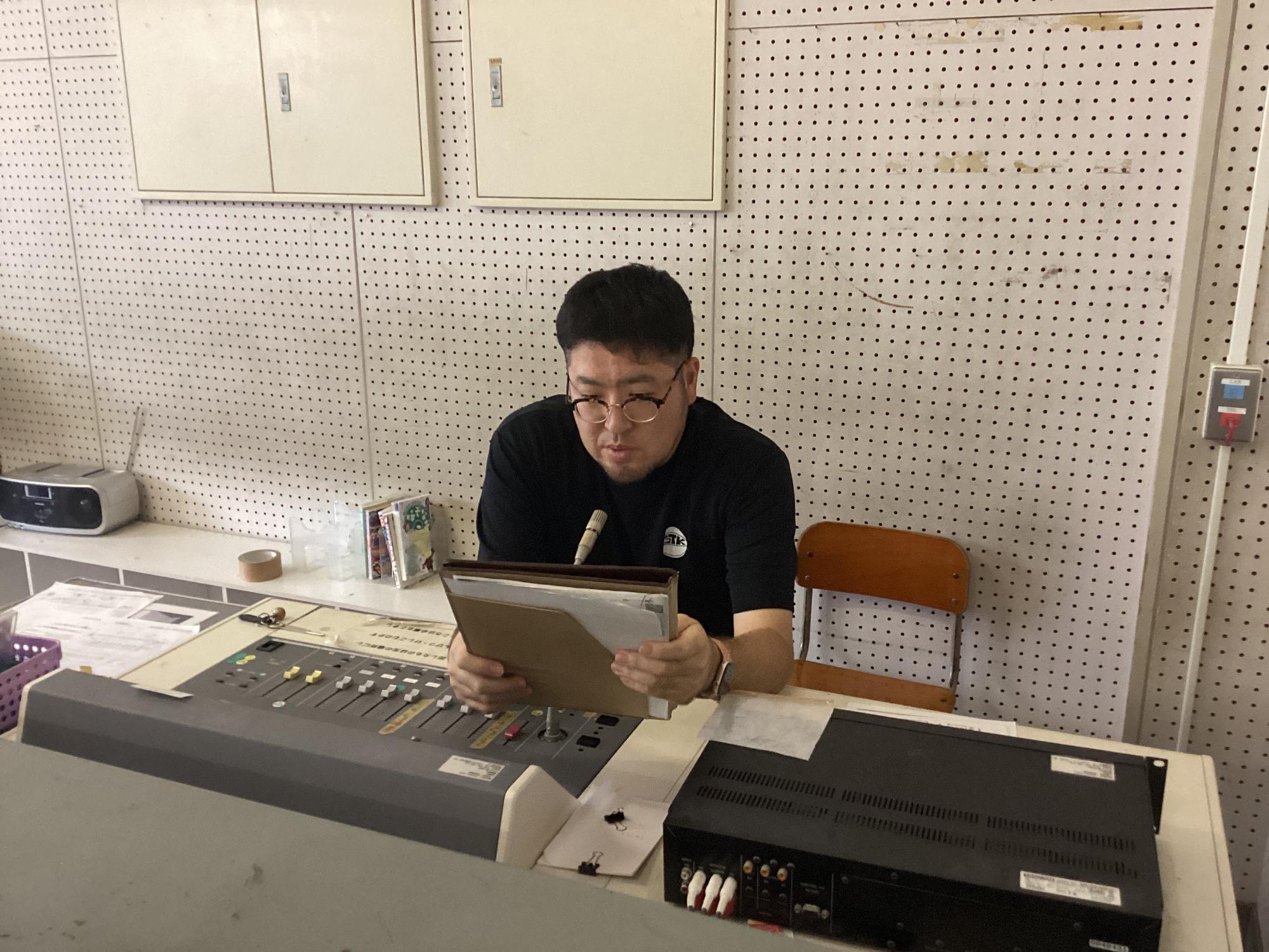 担当の教諭が放送室で話をしています。
