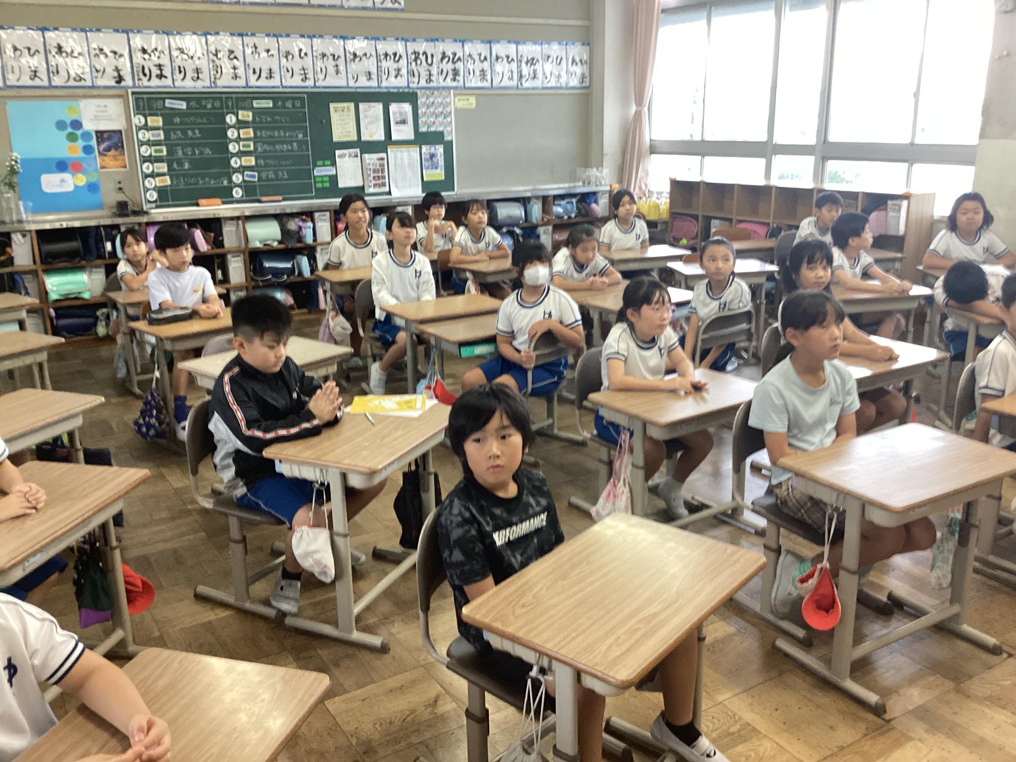 多くの児童が話を聞いています。