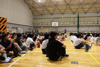 体育座りで講演を見ている全校生徒たちの写真