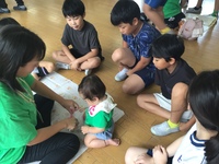 赤ちゃんとお母さんの様子を見守る4年生の写真