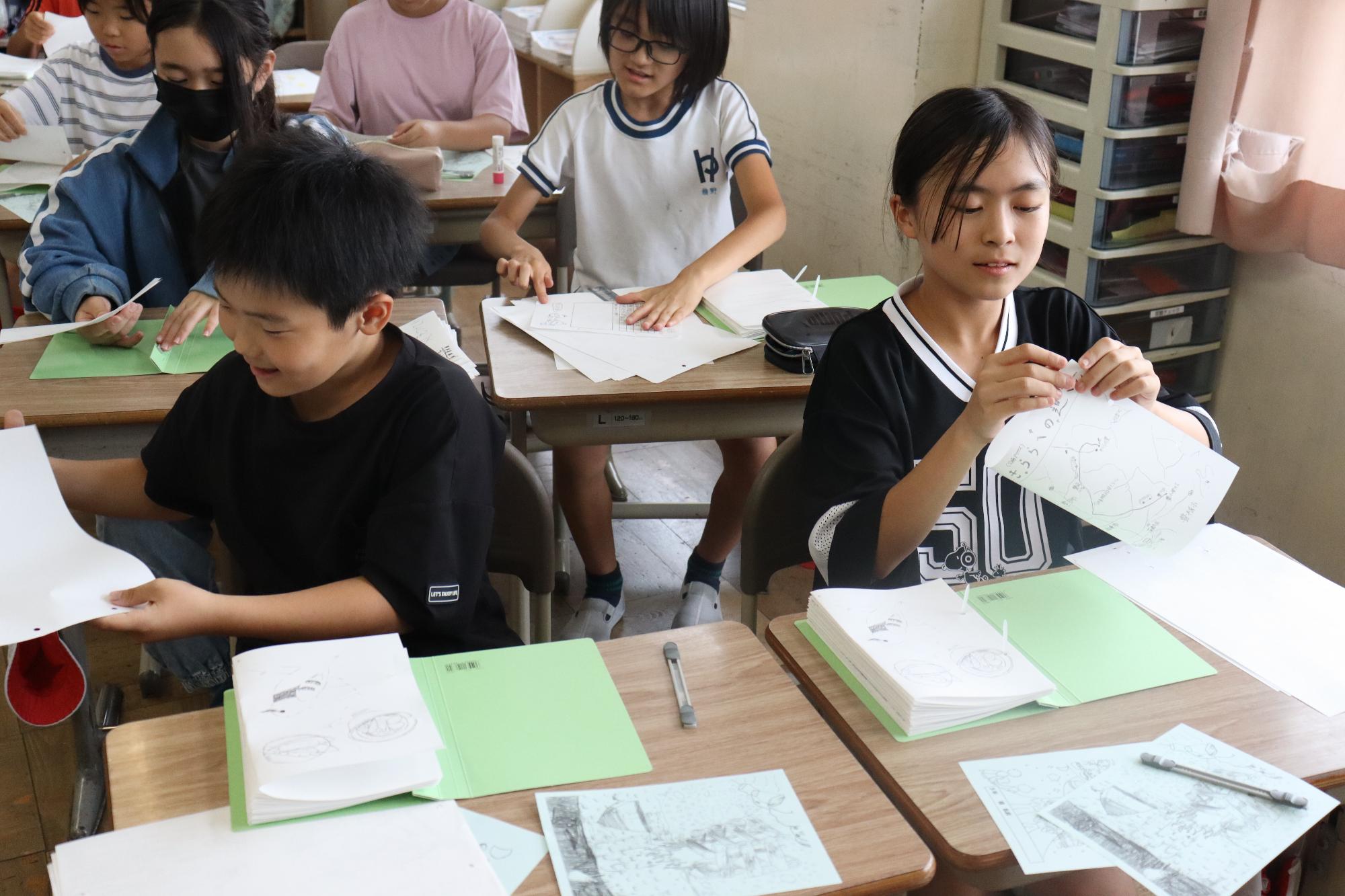 原稿を折り、ファイルに閉じます。