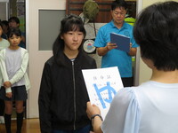 任命証を持っている校長先生に副会長に任命される児童の写真