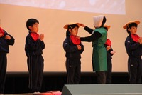 おじいさんが並んでいる地蔵に笠をかけているシーンを演じている様子の写真