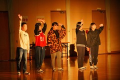 体育館の後方から手を振っている6年生の写真