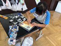 濡れても大丈夫なボンドで作品を接着している児童の写真