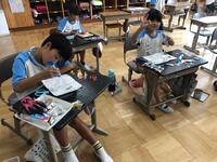 手につくくらい、ボンドをたっぷり塗っている児童たちの写真