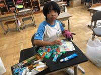 手袋を使ってアルミ缶を切っている児童の写真