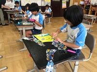 そらした羽にボンドをつけている児童たちの写真