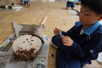 作品にマントのような布をつけている児童の写真