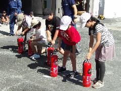 消火器での消火訓練に臨む子どもたち