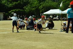 バトンを持った児童が走っている写真