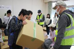 段ボールベッド設置のための段ボールを組み立てる子どもたち