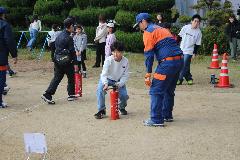 消火器を使って火を消す体験をする子ども