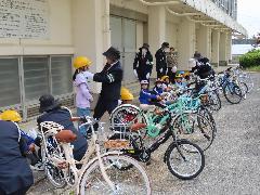 ヘルメットの確認を交通指導員さんにしてもらう子どもたち