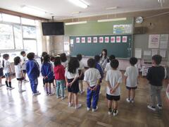 教室内で横2列に並んでいる児童たちの写真