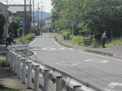 ガードレールの付いた歩道が左手にある道路の写真