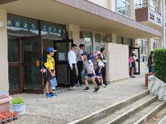 玄関で登校してきた子たちにあいさつをする計画委員