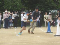 青いボールを持った児童が走っている写真