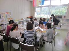 机を取り囲むように座って作業をしている人たちの写真