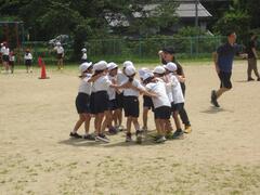 校庭で児童たちが一か所に固まっている写真