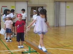 体育館に置かれた平均台に取り組む子供たちの写真