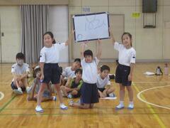 3人一緒に頭の上にボードを掲げている子供たちの写真