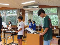 冷房の効いた音楽室で楽器演奏に取り組む子どもたち