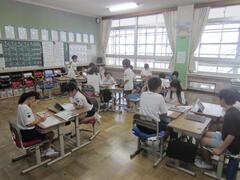 グループになって机をくっ付けて座る子供たちの写真