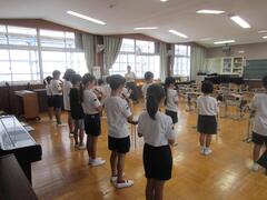 音楽室に並んでリコーダーを吹く子供たちの写真