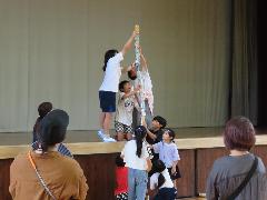 空き缶積みにチャレンジする子どもたちとそれを見守る保護者の皆さん