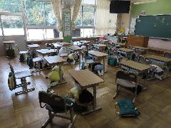 緊急地震速報を聞いて机の下にもぐる子どもたち