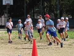 鬼ごっこで高学年を追いかける低学年の子どもたち