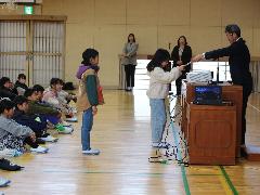 全校児童の前で表彰を受ける子ども