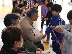 お世話になったみなさんに手作りのメダルを渡す子どもたち
