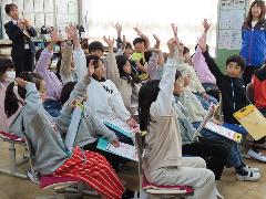 クイズの回答をするために手を挙げる子どもたち