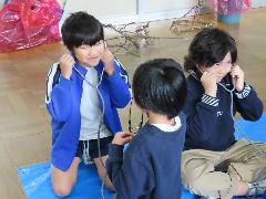 聴診器を使って友だちの心音を聞く子どもたち
