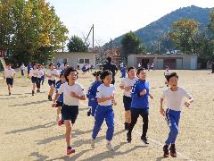 かけあし運動で運動場を元気に走る子どもたち