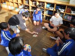 先生と一緒にカードゲームを楽しむ子どもたち