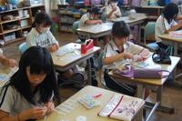 教室でそれぞれの席に座り、作業する生徒たちの写真