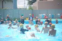 プールに入り水しぶきをあげている生徒たちの写真