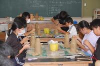 教室でそれぞれの自分の机の上でハニワを作っている生徒たちの写真