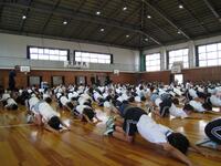 四つん這いになり背中を伸ばすような体操を行っている生徒たちの写真