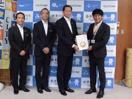 スーツ姿の男性4人が横に並んで立ち、右側の2名が一つの協定書を両手で持っている写真