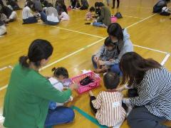 魚のうろこを貼って、自分の魚のお面を作っています。