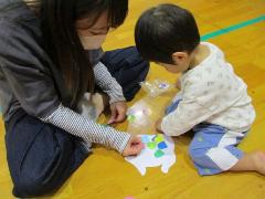 魚のうろこを貼って、自分の魚のお面を作っています。